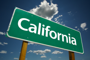Green California Road Sign with Dramatic Clouds and Sky.