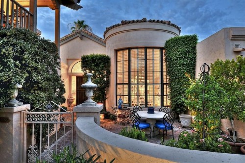 house with metal gate and patio furniture