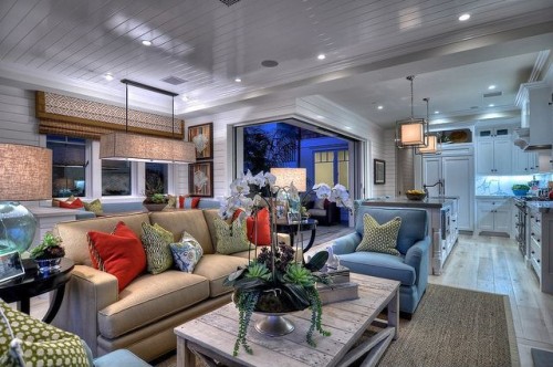 Red and green pillows are balanced by blue chairs.