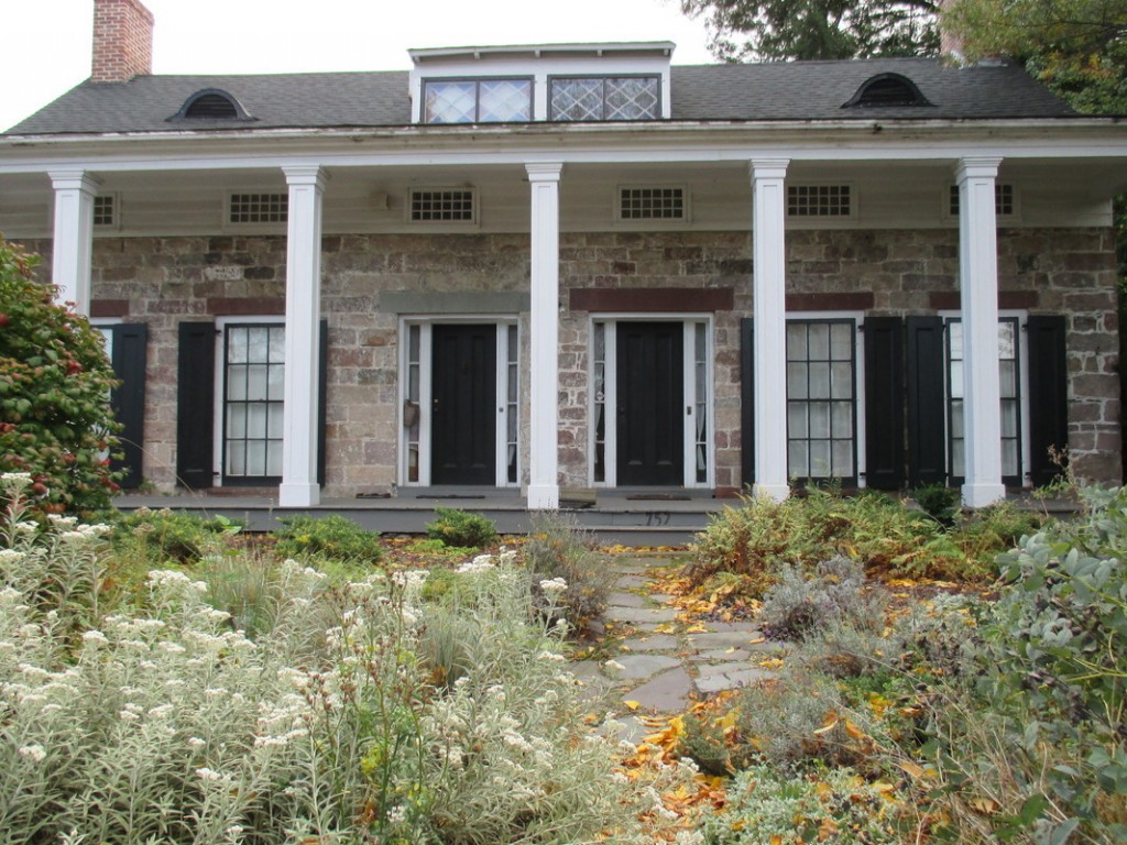 The farmhouse features a Greek Revival style verandah